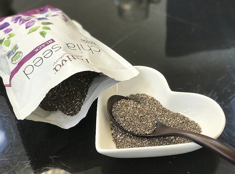 Taking a Spoonful From A Packet of Opened Chia Seeds 
