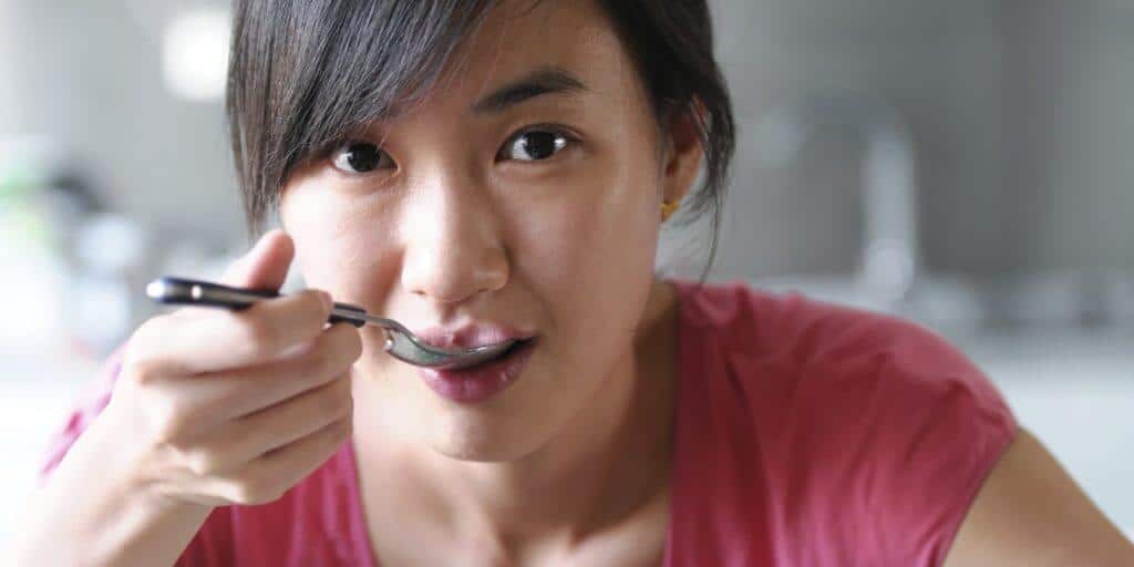 young asian lady enjoying a spoonful of food 