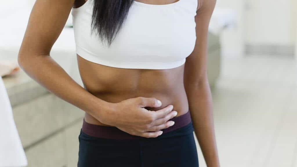 young woman feeling her lower abdominal area 